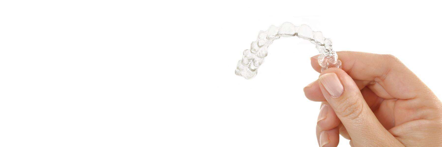 Hand holding up tray of Invisalign in Fredericksburg, VA