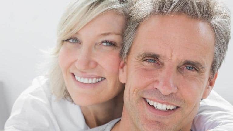 Happy couple wearing dental implants in Fredericksburg VA